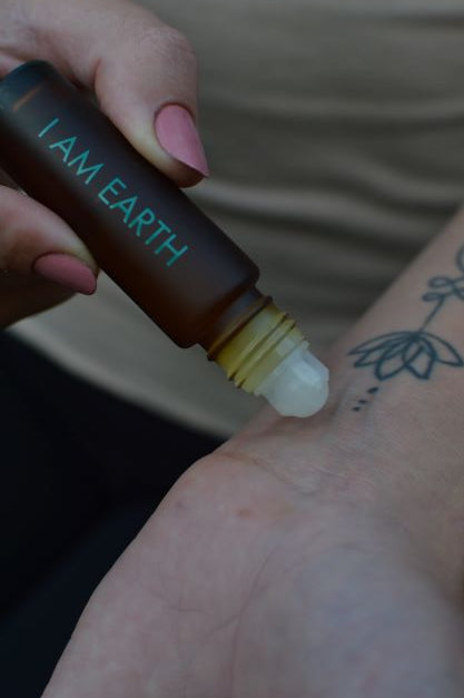 earth perfume oil on a wrist with lotus tatoo