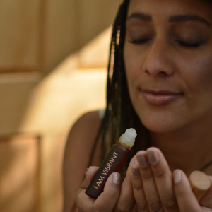 beautiful black woman smelling a natural perfume oil