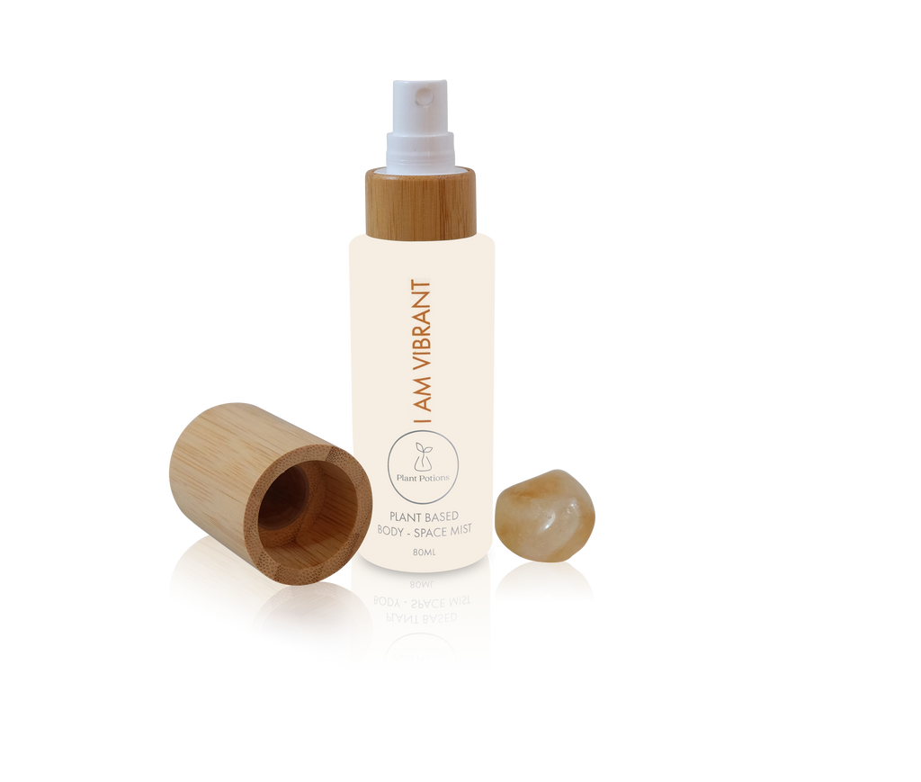 grapefruit body mist in a glass bottle with bamboo lid and citrine crystals